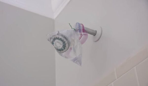 secure the vinegar filled bag over showerhead